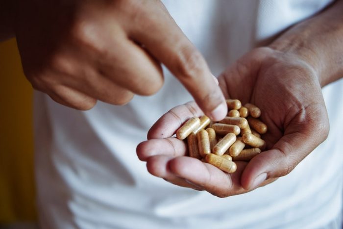 Athlete holding a handful of multivitamins