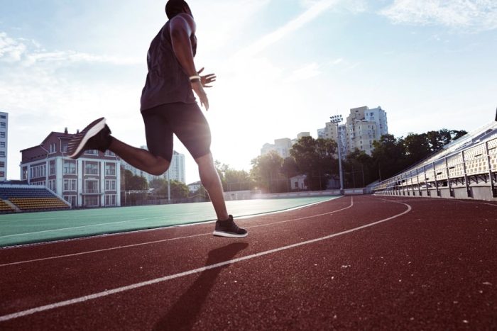 Runner mid-stride on athletics track