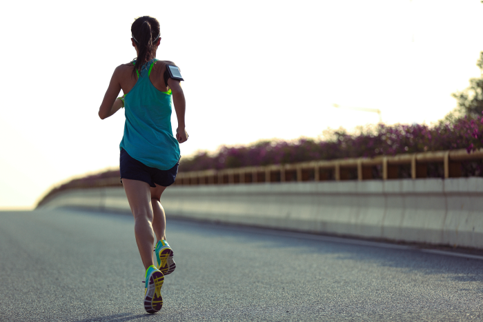 female athlete training for a marathon and jogging on the open road