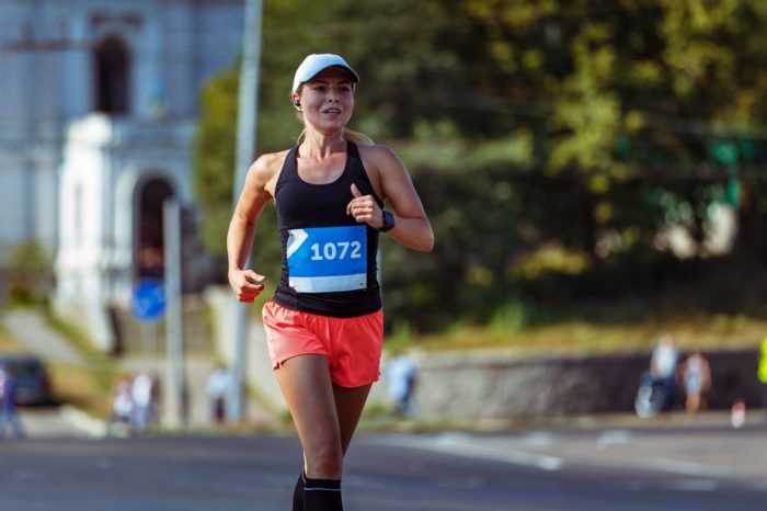 female athlete running a marathon in the city